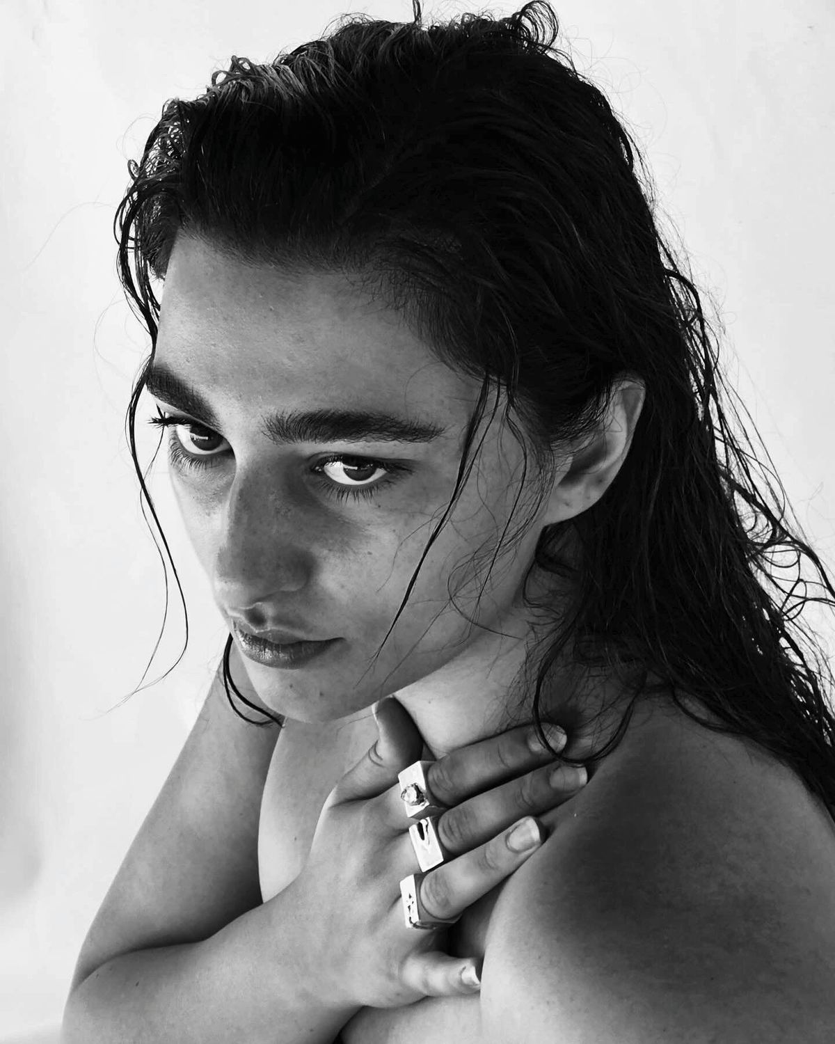 Retrato en blanco y negro de una modelo que lleva varios anillos de plata.