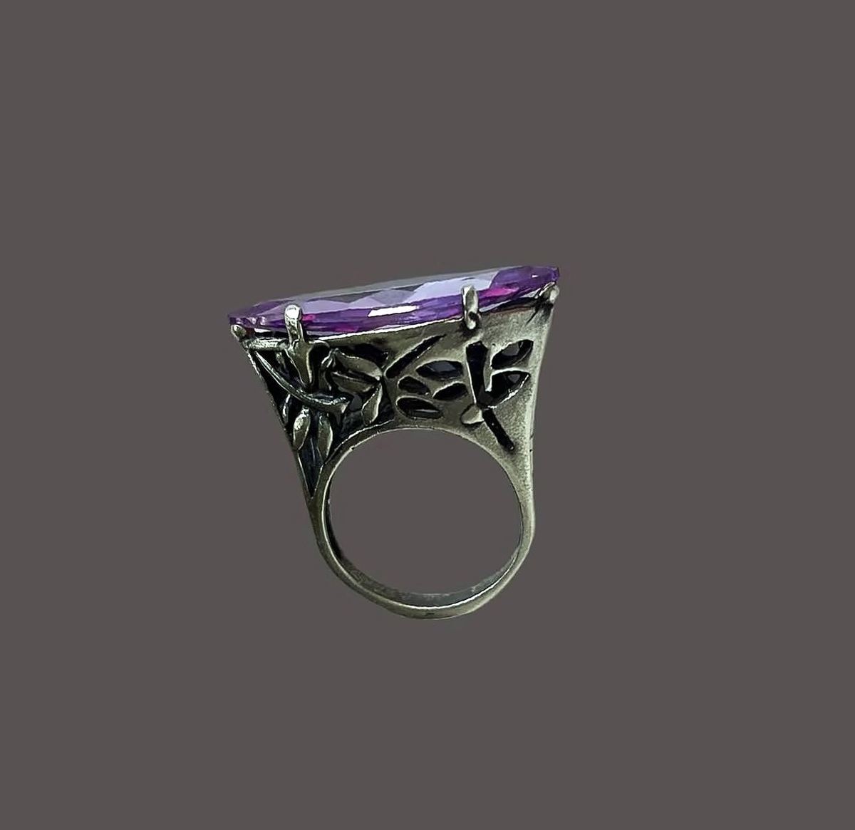 Marquise amethyst ring with a dragonfly gallery on a plum ground.