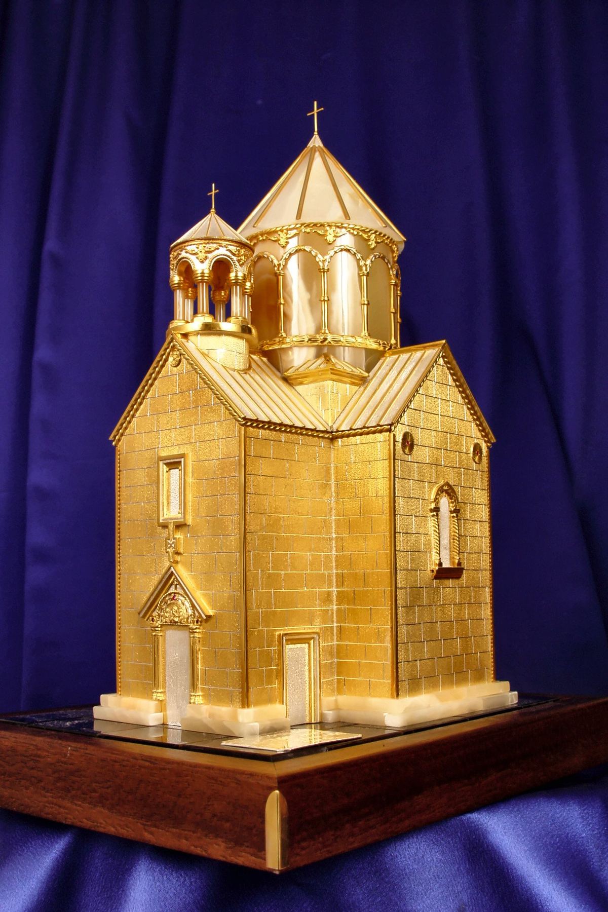 Maqueta dorada de la iglesia de Surp Stepanos sobre tela azul.