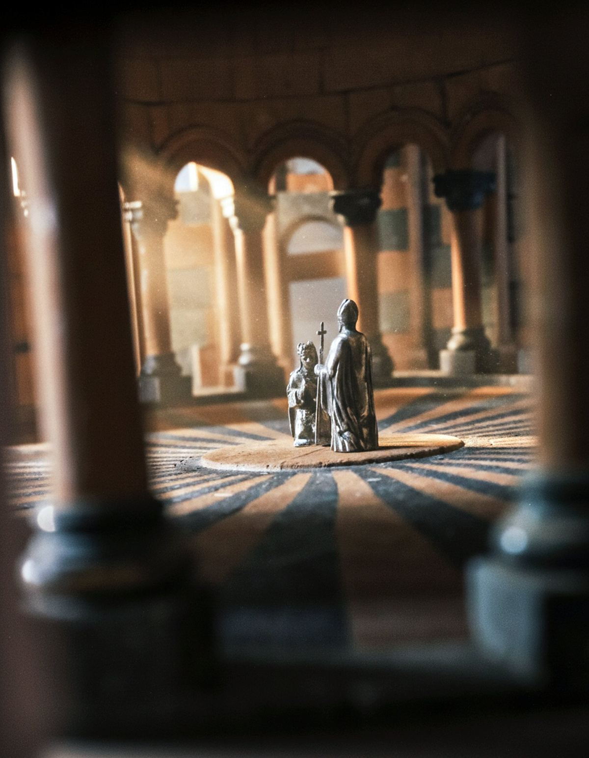 Silver figures of saints seen between the columns of the maquette.